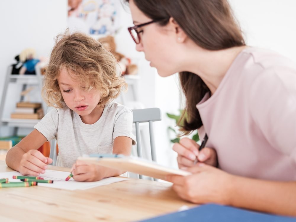 A clinician working one to one with a child at a table